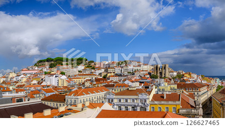 Scenic panoramic view of Lisbon historic Alfama district, St George castle on hill top with lush foliage, Gothic cathedral Se and colorful houses with terracotta rooftops on sunny day, clear blue sky Scenic panoramic view of Lisbon historic Alfama district, St George castle on hill top with lush foliage, Gothic cathedral Se and colorful houses with terracotta rooftops on sunny day, clear blue sky 126627465