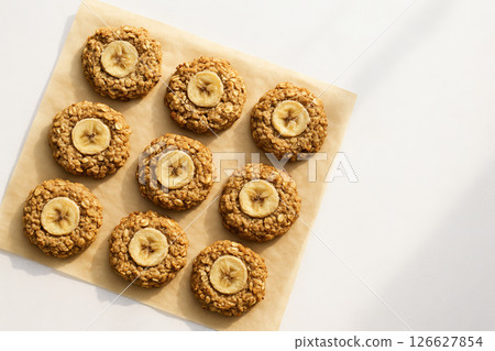 Delicious banana oatmeal cookies arranged on parchment paper with top-view composition. concept of homemade baking, simple recipes, healthy snack, copy space 126627854