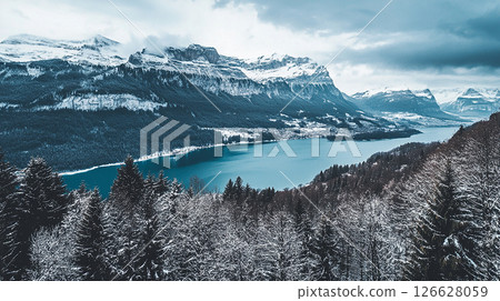 Majestic winter landscape featuring a serene lake surrounded by snow-covered mountains in Switzerland 126628059
