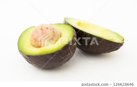Halved avocado with bone on white background 126628646