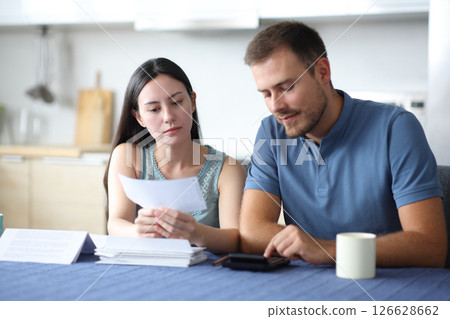 Interracial couple calculating expenses reading bill 126628662
