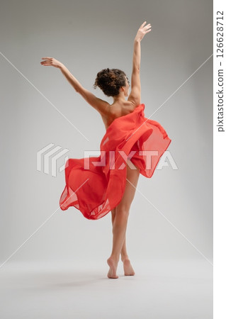Captivating dance performance by a nude woman with flowing red fabric 126628712