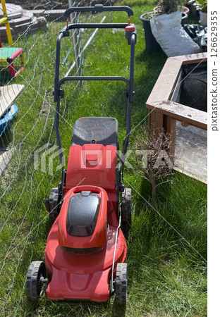 Lawn mover on green grass in sunny day Lawn mover on green grass in sunny day 126629355