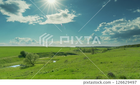 A Beautiful Lush Green Landscape Illuminated by Bright and Warm Sunlight, Captivating All Time lapse. 126629497