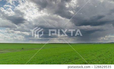 A Dramatic Cloudy Landscape Featuring Lush Green Fields and Rolling Hills Underneath the Skies Time lapse. A Dramatic Cloudy Landscape Featuring Lush Green Fields and Rolling Hills Underneath the Skies Time lapse. 126629535