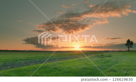 A Serene Sunset Over Expansive Green Fields and Countryside, Creating a Perfect Atmosphere Time lapse. A Serene Sunset Over Expansive Green Fields and Countryside, Creating a Perfect Atmosphere Time lapse. 126629630