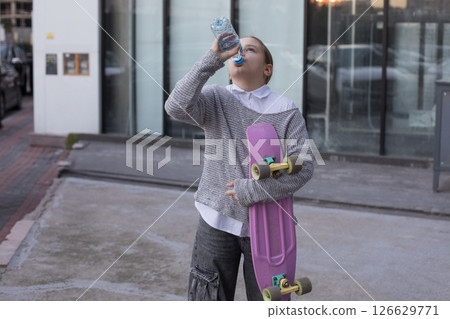 Young child girl drinking water from a bottle outdoors Young child girl drinking water from a bottle outdoors 126629771