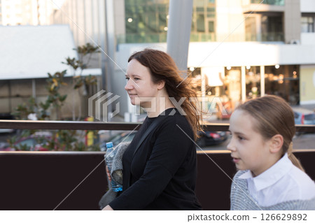 Mature woman and young girl child walking along the streets of the city 126629892