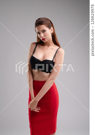 Elegant woman poses confidently in lingerie against studio backdrop 126629978