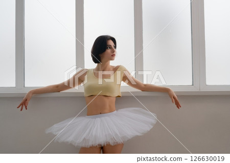 Woman practicing ballet in lingerie with a tutu in a dance studio Woman practicing ballet in lingerie with a tutu in a dance studio 126630019