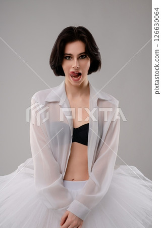 Woman in lingerie and ballet attire poses in a dance studio setting 126630064