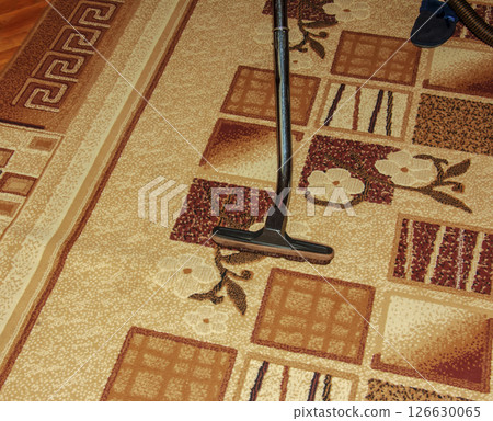 The head of a modern vacuum cleaner against the background of a carpet. Close. The head of a modern vacuum cleaner against the background of a carpet. Close. 126630065