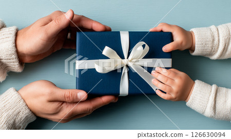 Happy Father's Day. Child and adult hands sharing a blue gift 126630094