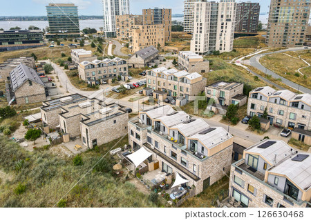 Aerial view of modern residential buildings interspersed with greenery, showcasing a blend of nature and contemporary living spaces. Aerial view of modern residential buildings interspersed with greenery, showcasing a blend of nature and contemporary living spaces. 126630468