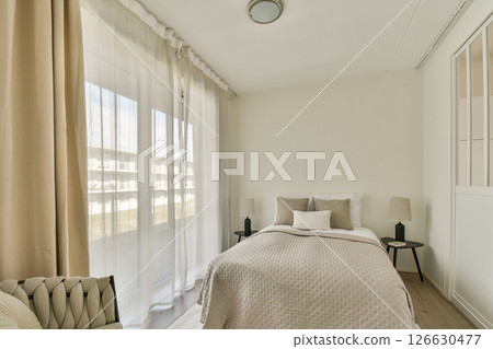 A serene and minimalist bedroom featuring soft linens, natural light filtering through sheer curtains, and a simple color palette for a relaxing atmosphere. A serene and minimalist bedroom featuring soft linens, natural light filtering through sheer curtains, and a simple color palette for a relaxing atmosphere. 126630477