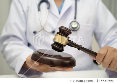 Doctor holding judge gavel, forensic medicine, medical law and crime justice. 126630660