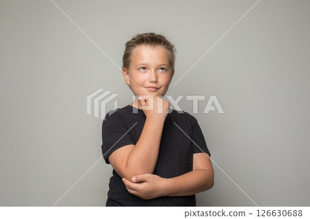 Portrait of young boy child looking up and thinking on white background 126630688