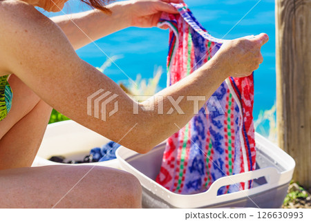 Female washing laundry on holidays trip. Female washing laundry on holidays trip. 126630993