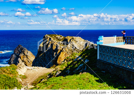 Tourist with camera on Asturias coast, Spain 126631008