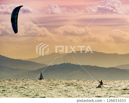 Kite surfer riding waves. Kiteboarding sport. 126631033