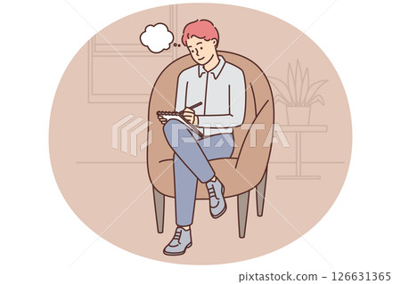Adult man sits in cozy chair and makes notes in notebook making plans for day 126631365
