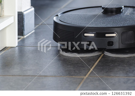 Robot vacuum cleaner with dust, real life photo, saves time and goes into hard-to-reach places Robot vacuum cleaner with dust, real life photo, saves time and goes into hard-to-reach places 126631392