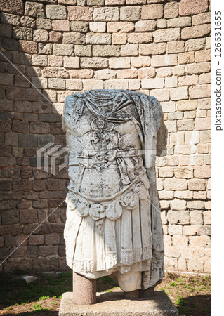 Ancient Roman statue torso in military armor displayed against stone wall at Pergamon archaeological site 126631655