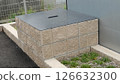 An old well with a metal lid in a parking lot 126632300