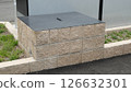 An old well with a metal lid in a parking lot 126632301