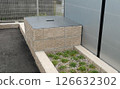 An old well with a metal lid in a parking lot 126632302