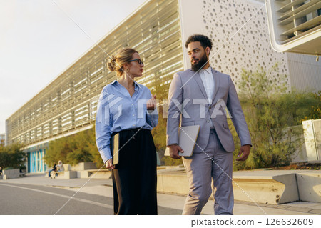 A group of professional colleagues is seen walking together in an urban environment today 126632609