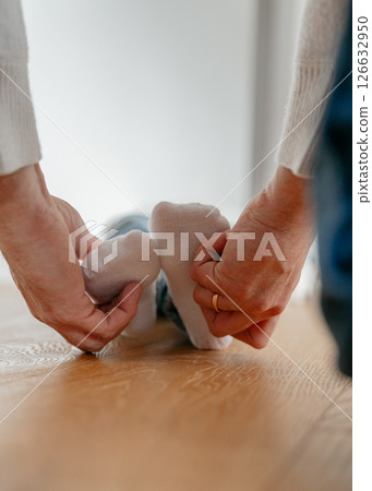 A dad holds his 4-year-old son's feet in his socks and tickles them. High quality photo A dad holds his 4-year-old son's feet in his socks and tickles them. High quality photo 126632950