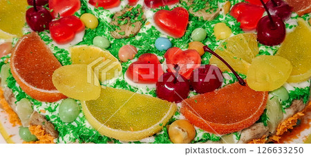 Sponge cake with fruits. Fruity background with marmalade, orange, dragee and cherry. Sponge cake with fruits. Fruity background with marmalade, orange, dragee and cherry. 126633250