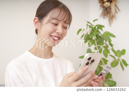 一位年輕女子用智慧型手機付款 一位年輕女子用智慧型手機付款 126633262