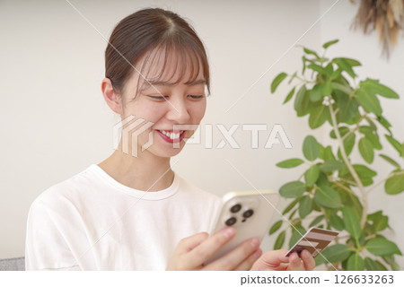 Young woman making payment on her smartphone Young woman making payment on her smartphone 126633263
