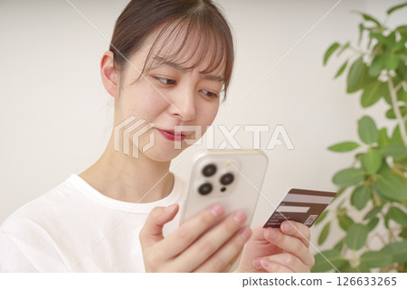 Young woman making payment on her smartphone Young woman making payment on her smartphone 126633265