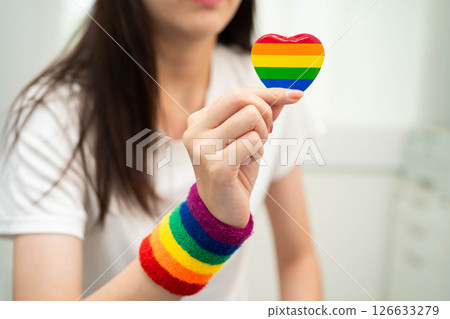Asian LGBT woman holding heart rainbow flag. 126633279