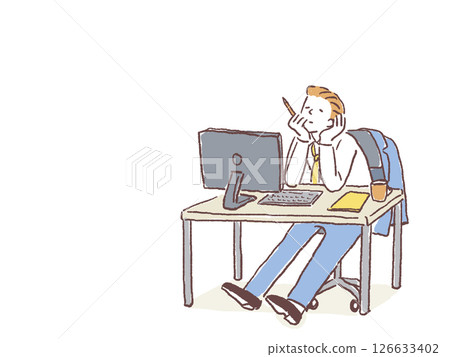 A young man in a suit sitting at a desk in the office 126633402