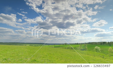 A Serene and Picturesque Green Landscape Set Against Dramatic and Striking Skies Above Time lapse. A Serene and Picturesque Green Landscape Set Against Dramatic and Striking Skies Above Time lapse. 126633497