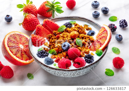 Granola with yogurt and fresh fruit. Organic gourmet muesli on a marble table 126633817
