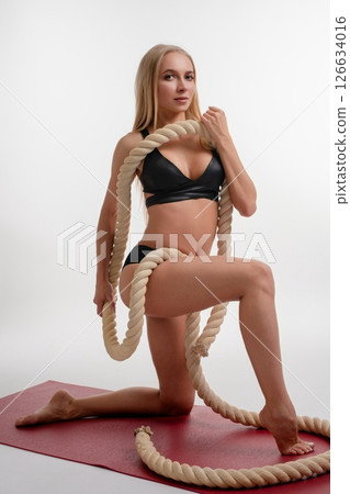 Strong woman showcasing beauty and strength in a sport studio setting Strong woman showcasing beauty and strength in a sport studio setting 126634016