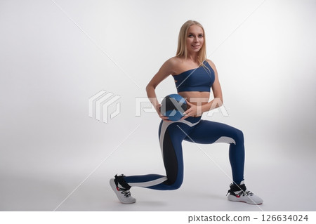 Elegant woman demonstrating sport and fitness techniques in a studio setting Elegant woman demonstrating sport and fitness techniques in a studio setting 126634024