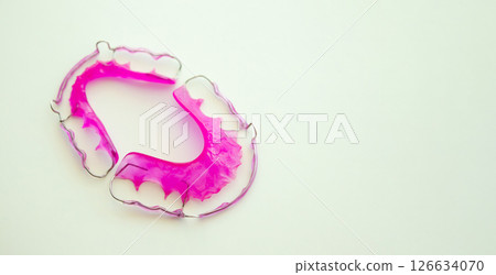 Pink acrylic dental retainer on white background Pink acrylic dental retainer on white background 126634070