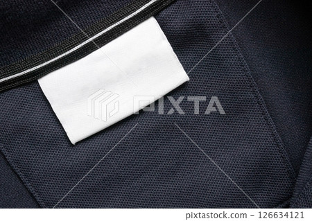 Blank white laundry care clothes label on black shirt fabric texture background Blank white laundry care clothes label on black shirt fabric texture background 126634121