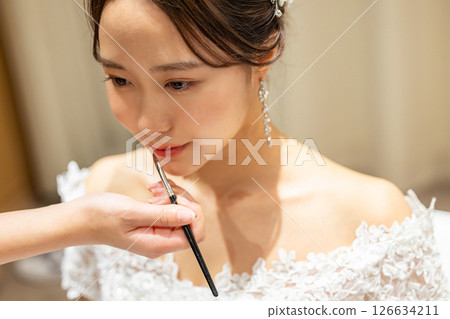 Bride getting ready in the waiting room on her wedding day 126634211