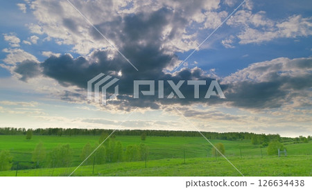 A Serene and Picturesque Green Landscape Set Beneath Dramatic and Beautiful Clouds Above Time lapse. 126634438