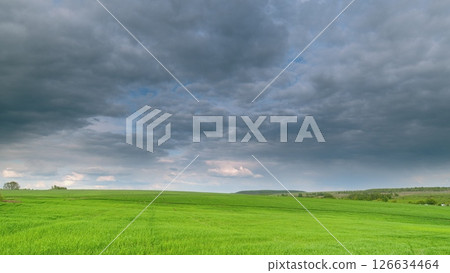 Dramatic and Beautiful Cloudy Sky Displaying Over Lush and Serene Green Fields Landscape Time lapse. 126634464