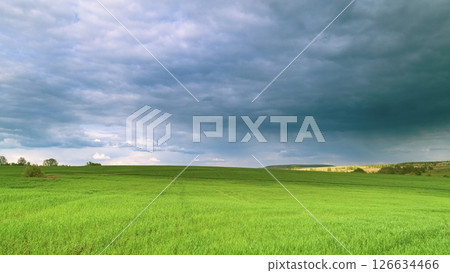 The Serene Green Fields Lie Under a Dramatic and Beautiful Cloudy Sky Above Them Time lapse. The Serene Green Fields Lie Under a Dramatic and Beautiful Cloudy Sky Above Them Time lapse. 126634466