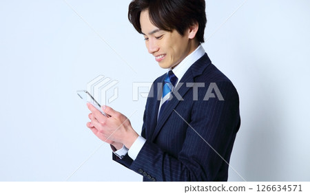 一名男性辦公室職員操作智慧型手機的圖片 126634571
