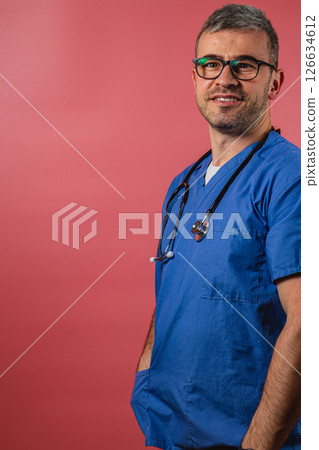 Young healthcare professional smiles confidently against a vibrant backdrop 126634612